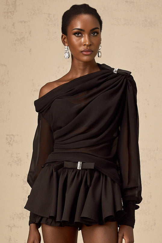 Woman wearing black asymmetric tulle blouse and matching skirt set