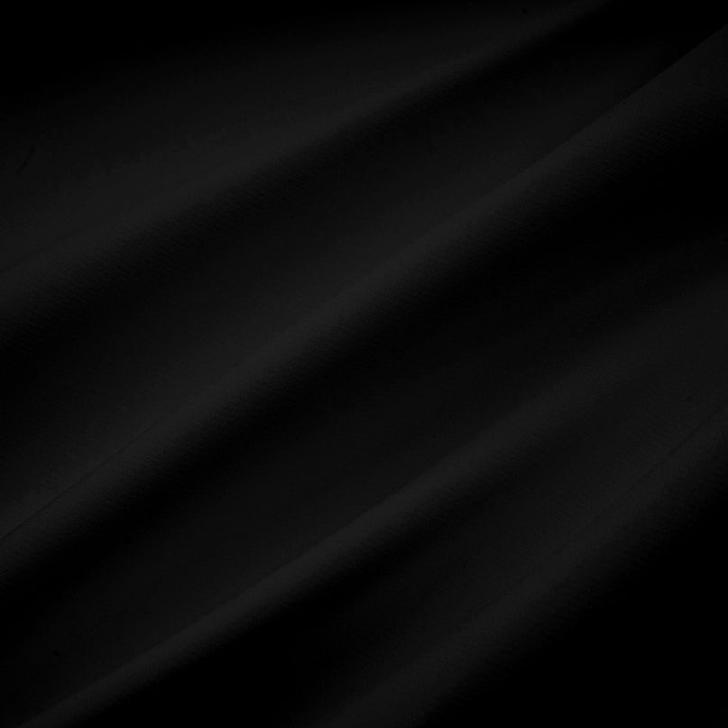 Woman wearing black asymmetric tulle blouse and matching skirt set