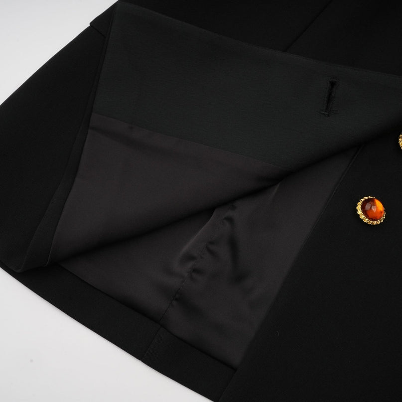 Woman wearing black blazer dress with single button closure and tailored fit