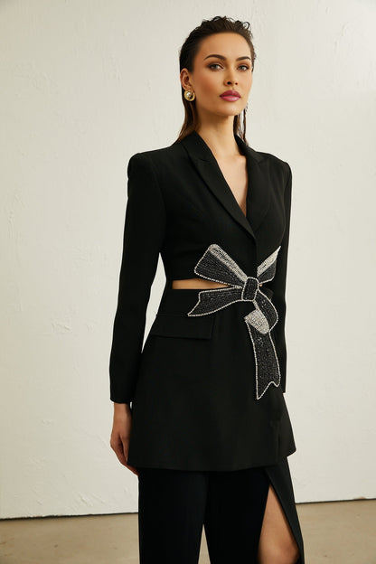 Woman wearing black blazer with bowknot detail and cutout design