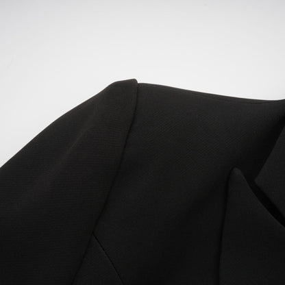 Woman wearing black blazer with bowknot detail and cutout design