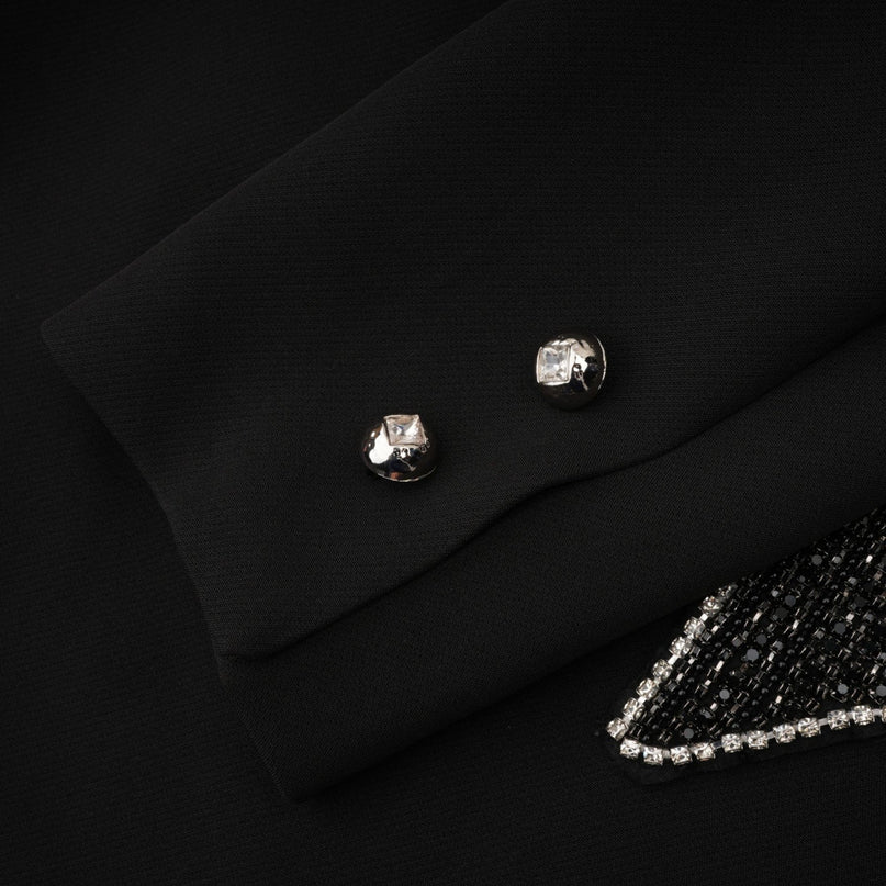 Woman wearing black blazer with cutout design and decorative bow detail at waist