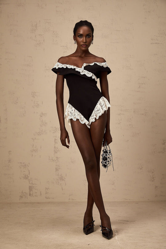 Woman wearing black bodysuit with lace trim details and thin shoulder straps