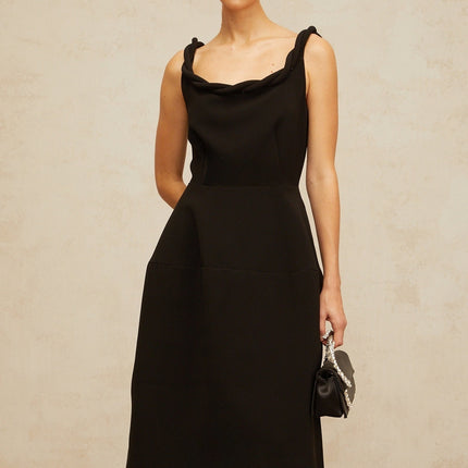 Woman wearing black braided puff sleeve midi dress with fitted bodice and full skirt