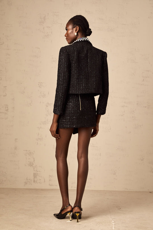 Woman wearing black crystal tweed jacket and matching skirt set Delphine collection Elegant formal outfit with textured fabric and subtle sparkle