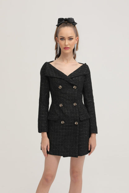 Woman wearing black double breasted coat dress with long sleeves and knee length skirt