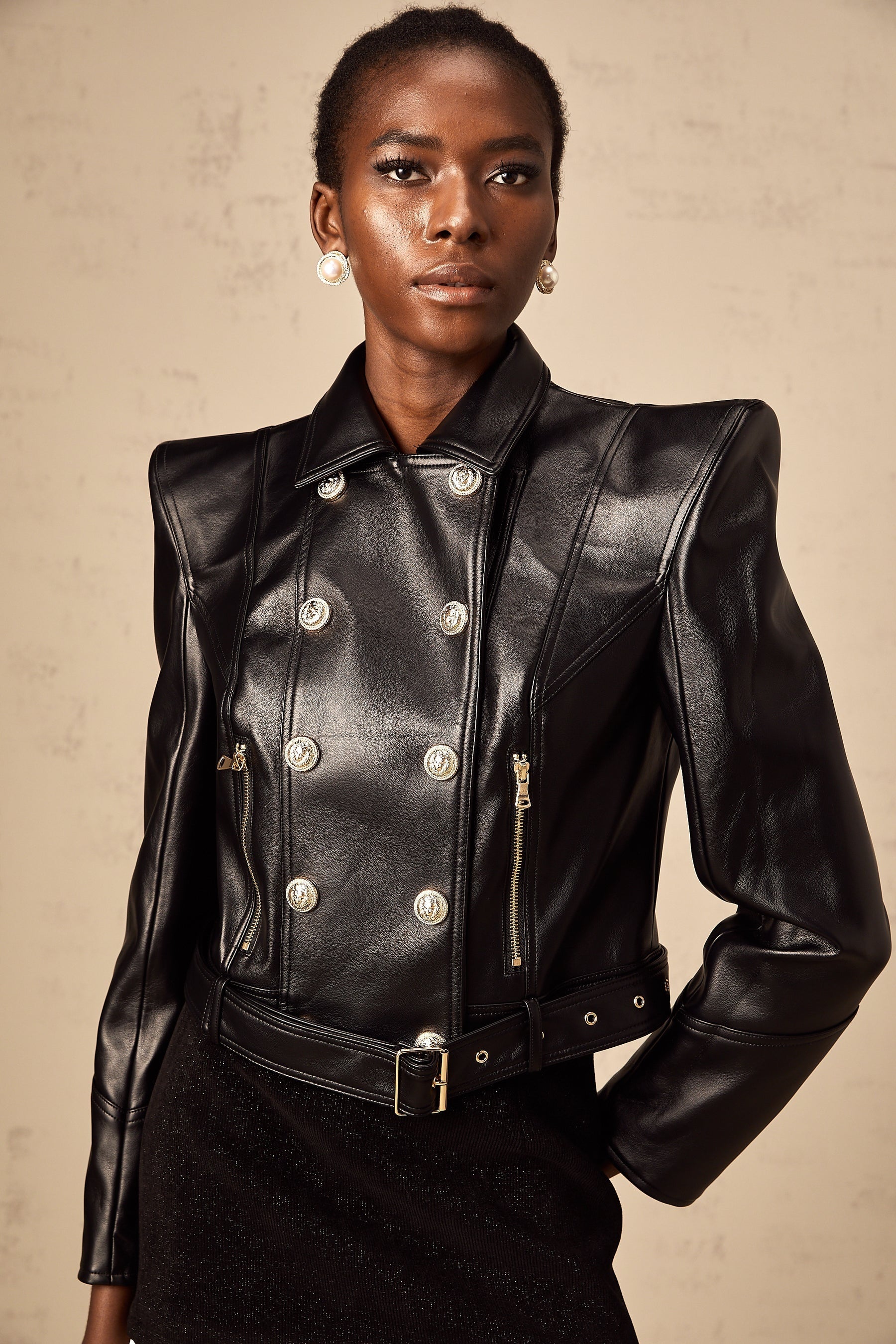 Woman wearing black faux leather jacket with double breasted front closure