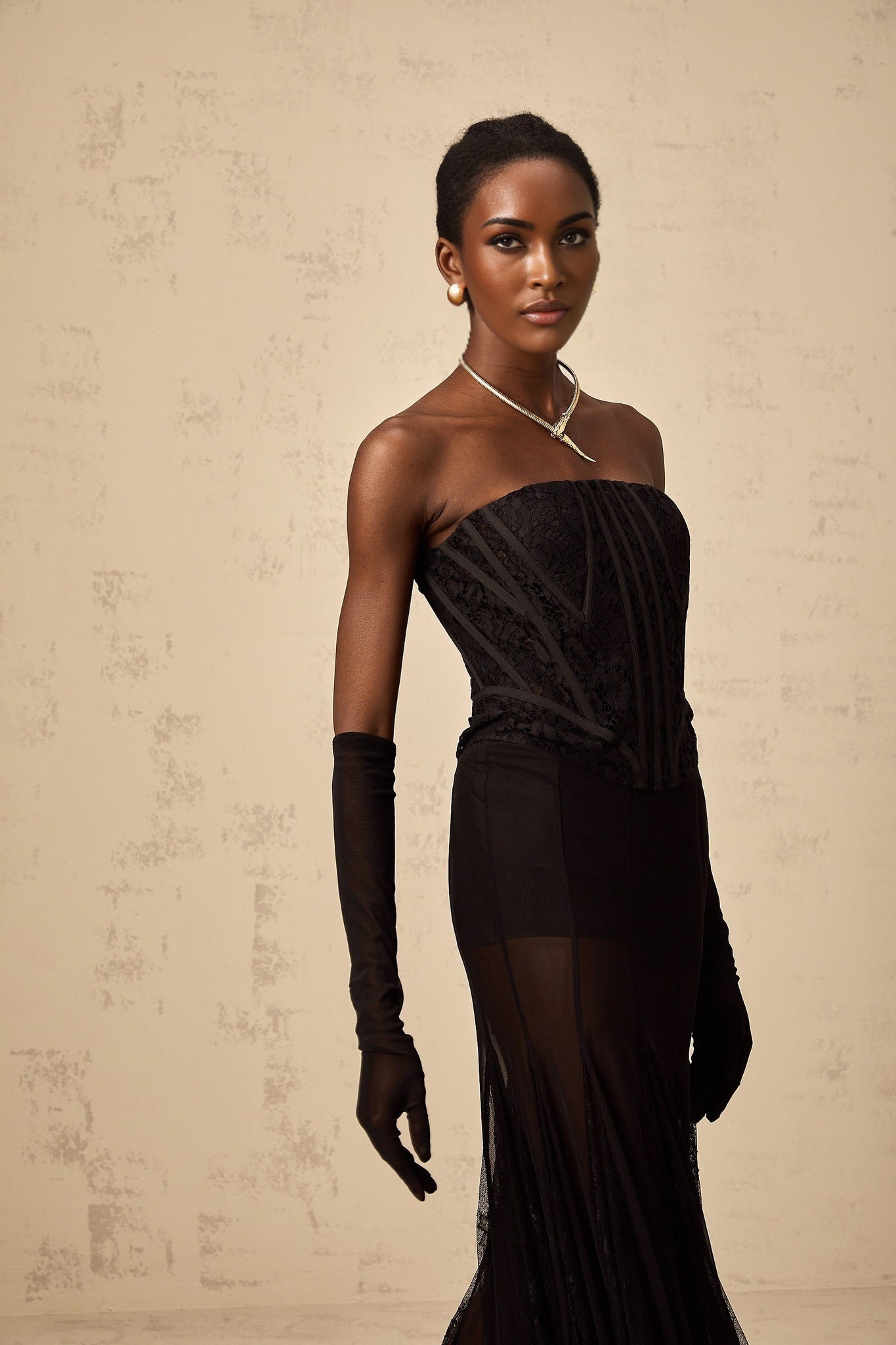 Woman wearing black floral lace corset skirt and gloves matching set Violaine style