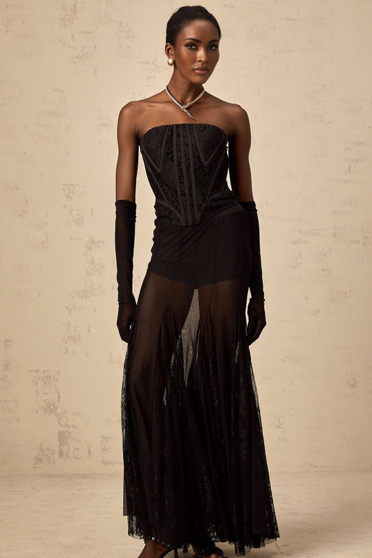 Woman wearing black floral lace corset skirt and gloves set with delicate patterns and elegant design