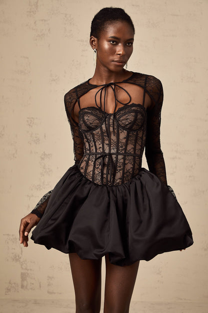 Woman wearing black floral lace sleeveless dress with matching vest Two piece set with intricate lace pattern Elegant formal outfit