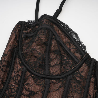 Woman wearing black floral lace sleeveless vest over matching dress with floral lace pattern