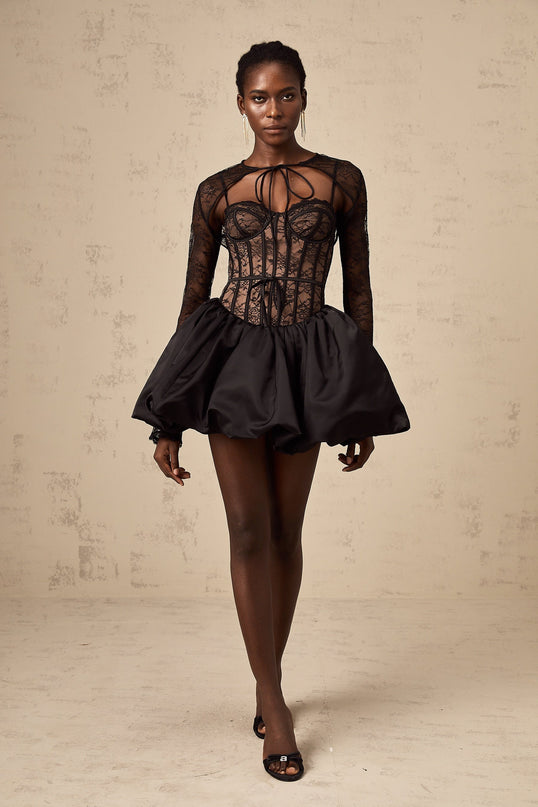 Woman wearing black floral lace sleeveless vest over matching dress with floral lace pattern