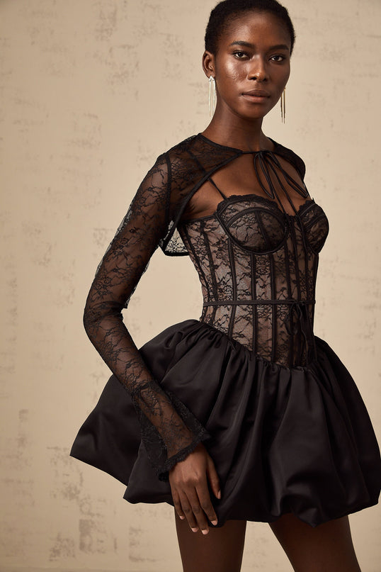 Woman wearing black floral lace sleeveless vest over matching dress