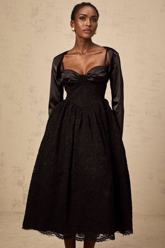 Woman wearing black floral lace top and matching dress set elegant sleeveless design with delicate lace pattern