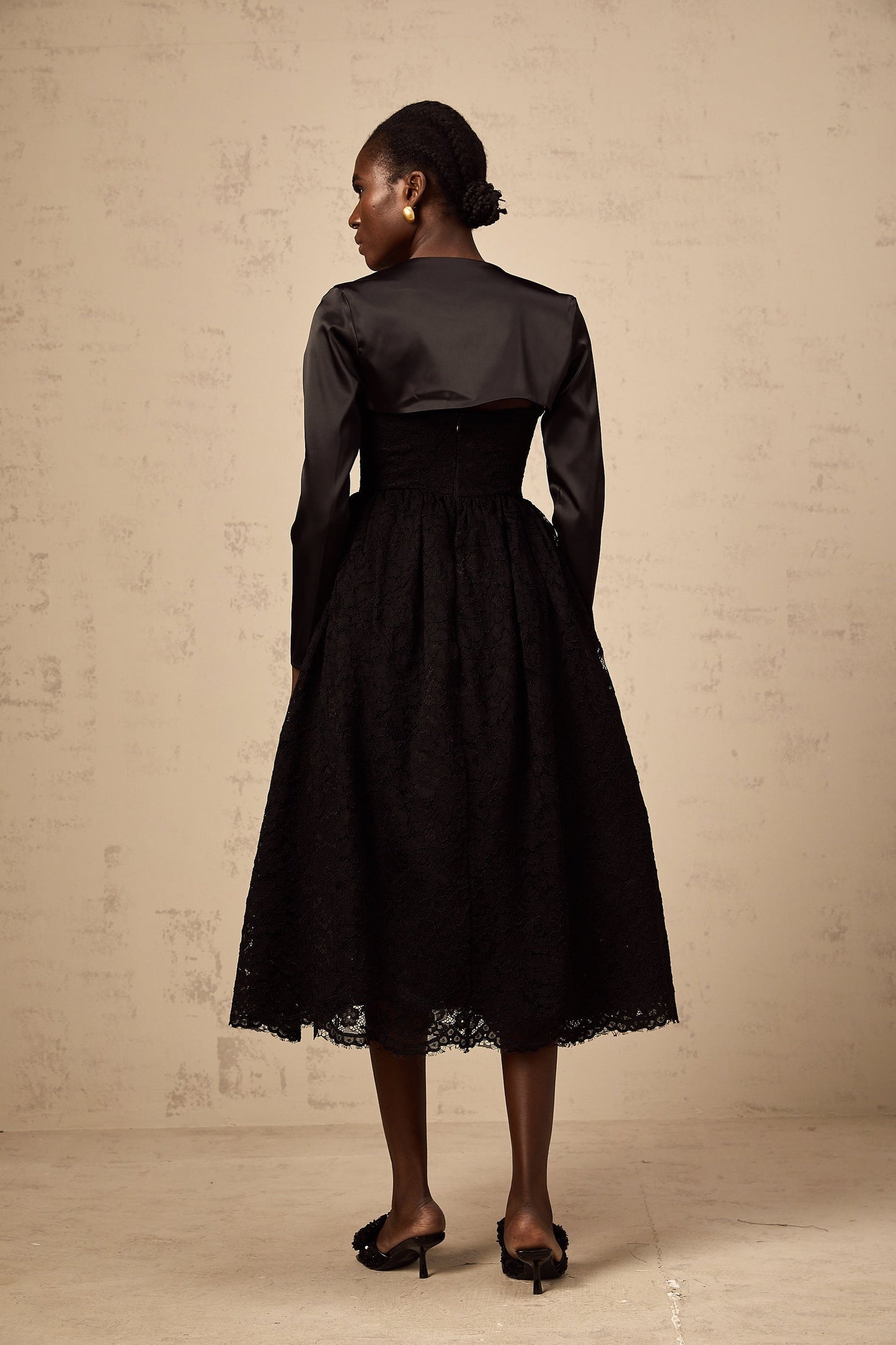Woman wearing black floral lace top and matching dress set with delicate lace pattern and sheer details