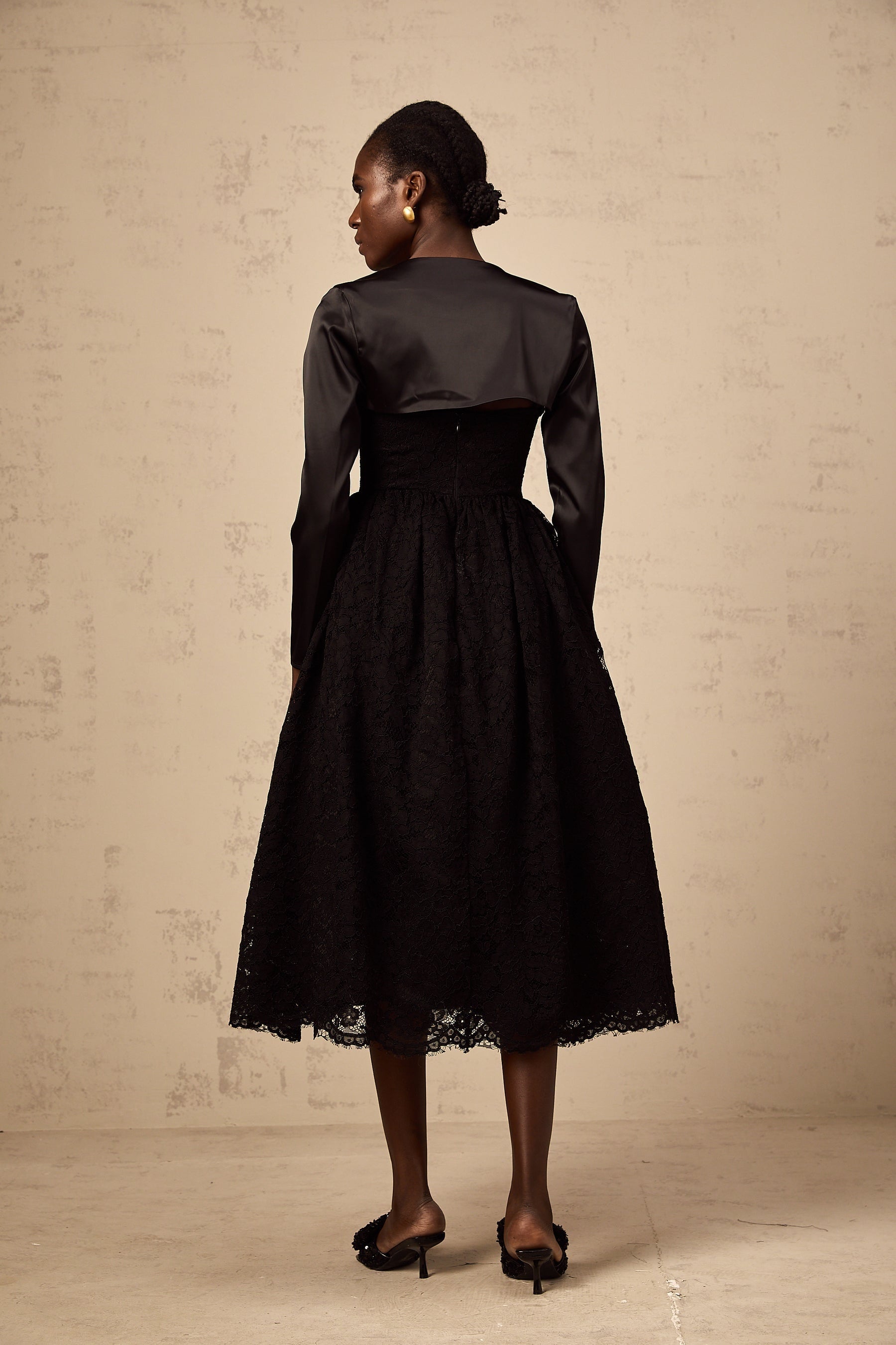 Woman wearing black floral lace top and matching dress set with delicate lace pattern and sheer details