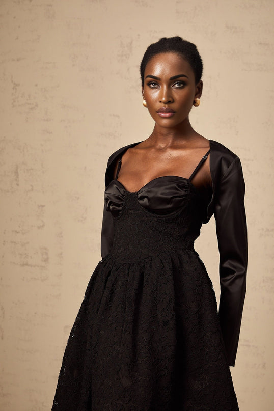 Woman wearing black floral lace top and matching dress set with delicate pattern details and elegant design