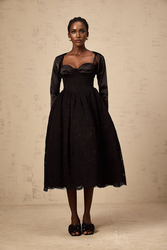 Woman wearing black floral lace top and matching dress set with delicate sheer details and feminine silhouette