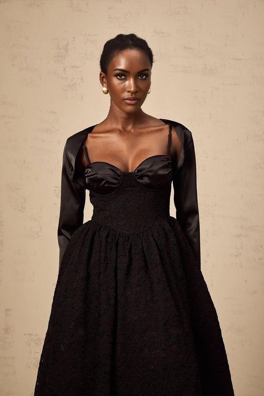 Woman wearing black floral lace top and matching dress set with delicate sheer details and floral pattern