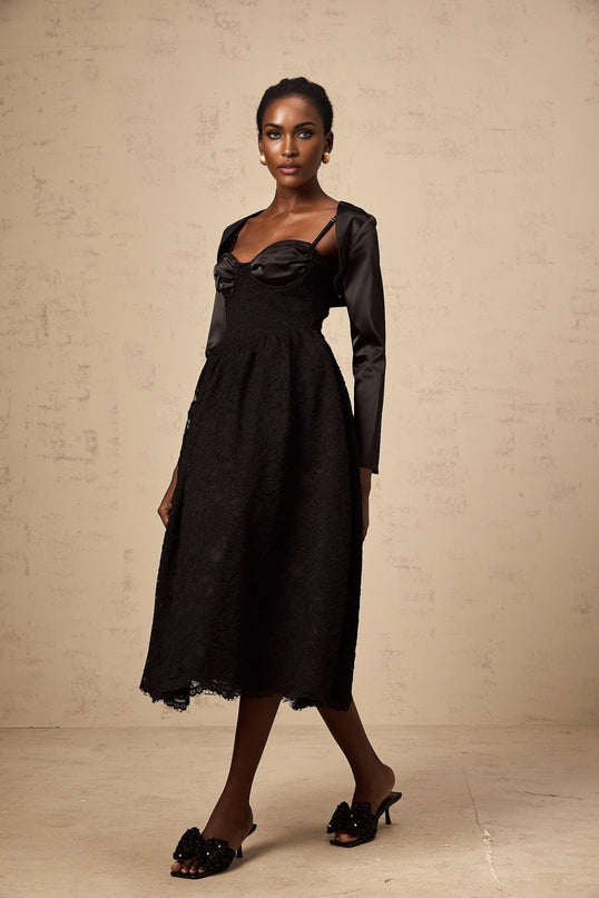 Woman wearing black floral lace top and matching dress set with sheer details and delicate pattern