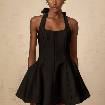 Woman wearing black halterneck mini dress with bow detail