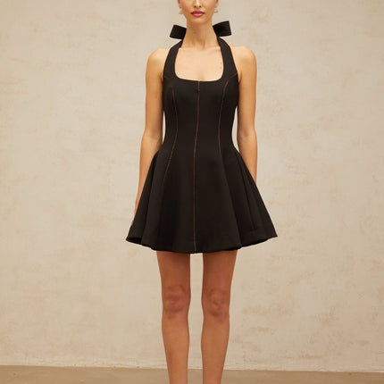 Woman wearing black halterneck mini dress with bow detail