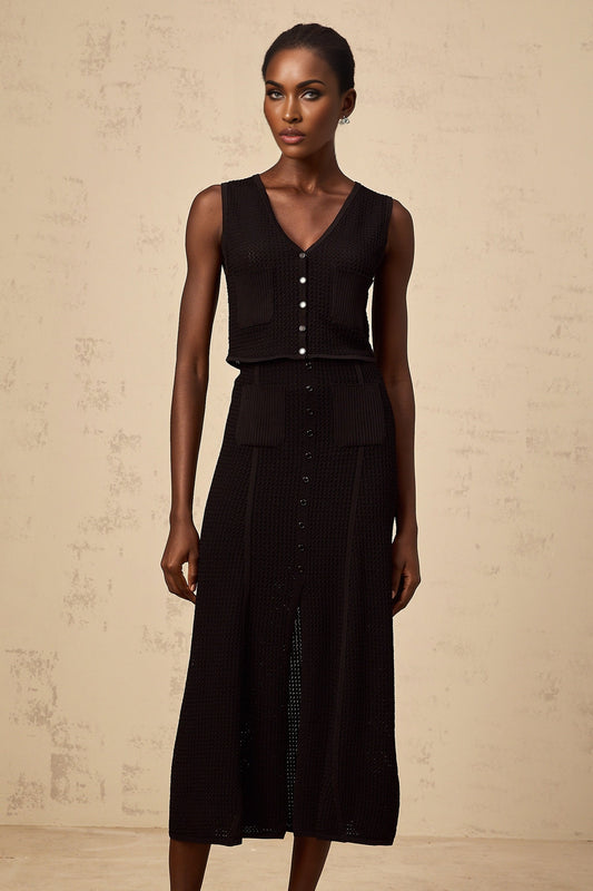 Woman wearing black knit top and skirt set with delicate pointelle pattern Babette matching outfit