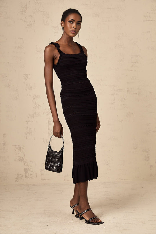 Woman wearing black knitted matching set with ruffled top and skirt named Celeste