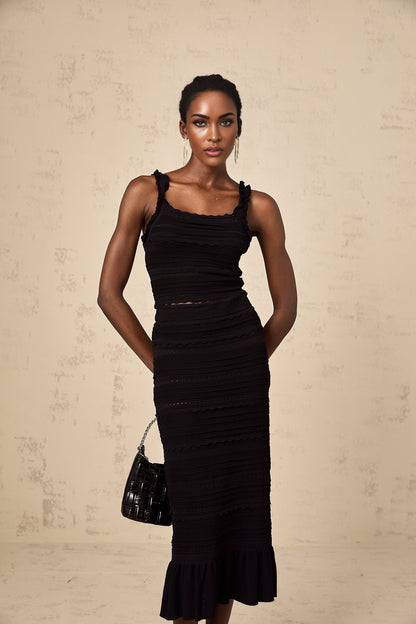Woman wearing black knitted matching set with ruffled top and skirt