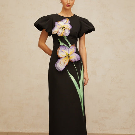 Woman wearing black midi dress with sequined floral embroidery standing in elegant pose