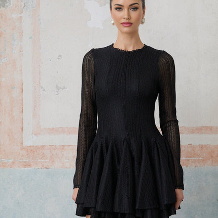 Woman wearing black mini dress with puff sleeves and pointelle knit pattern