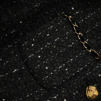 Woman wearing black mini dress with sequin panels and tweed fabric short sleeves fitted silhouette