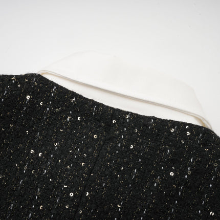 Woman wearing black mini dress with sequin panels and tweed fabric short sleeves fitted silhouette