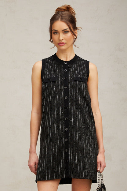 Woman wearing black mini dress with vertical sequin stripes knit fabric short length sleeveless design inspired by Zelda style