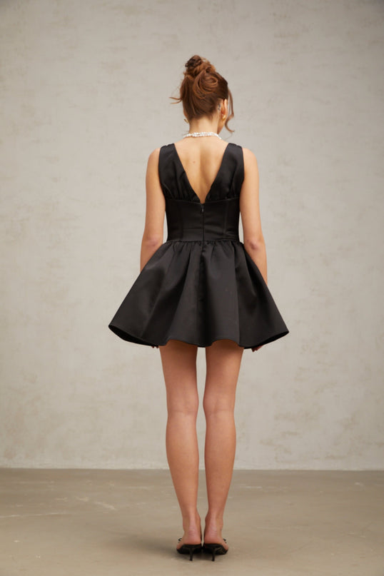 Woman wearing black mini dress with Vneck and flared skirt