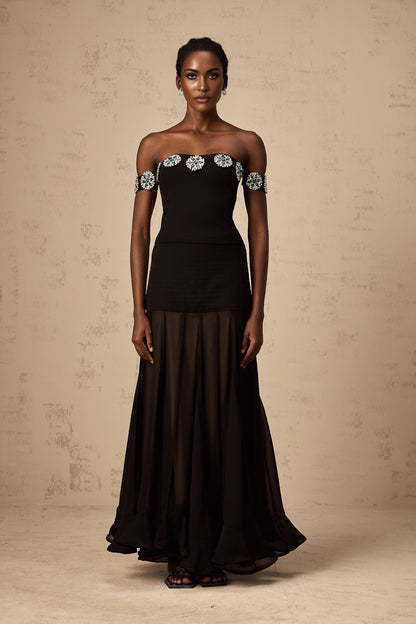 Woman wearing black off shoulder top with embellished details