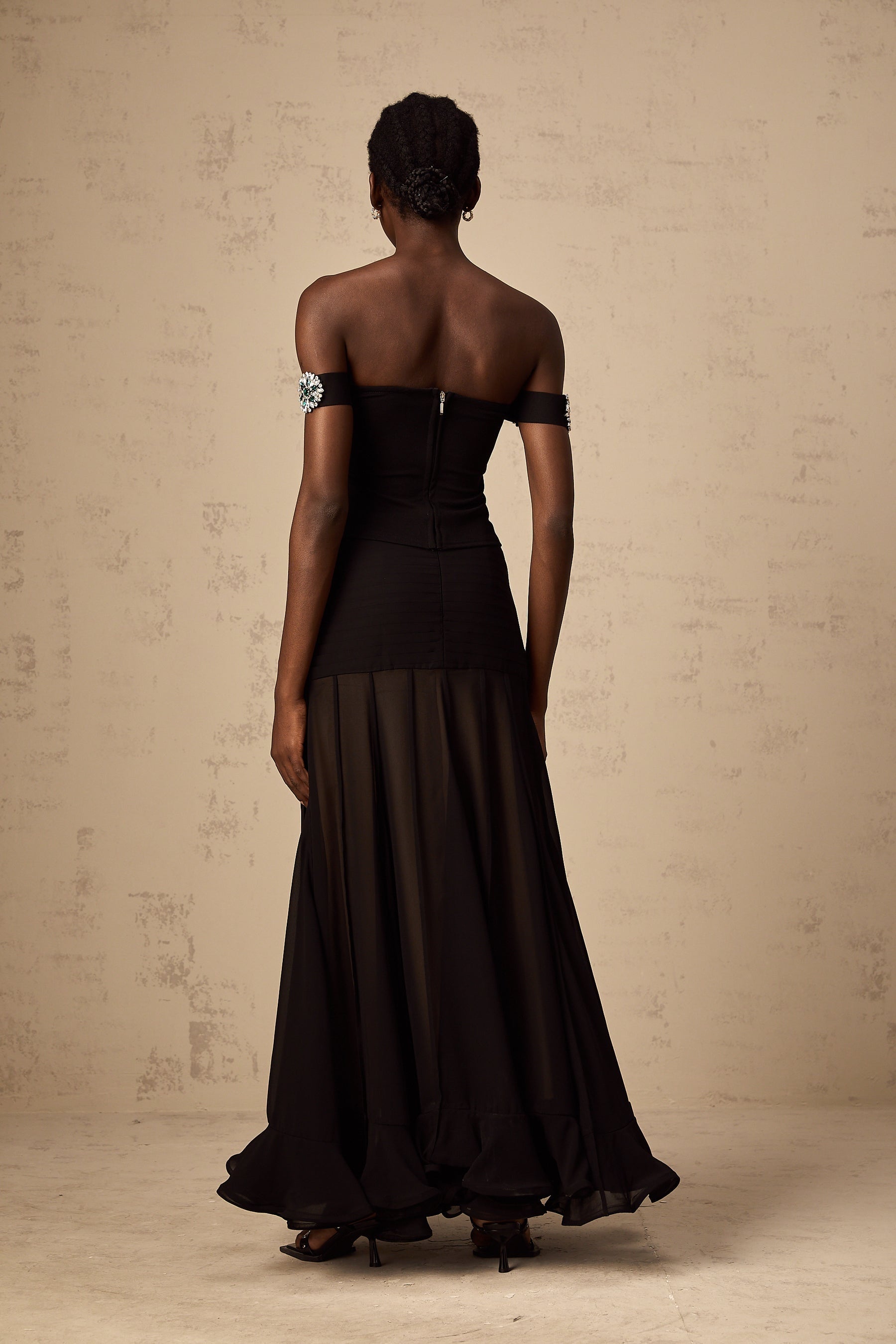 Woman wearing black off shoulder top with embellishments