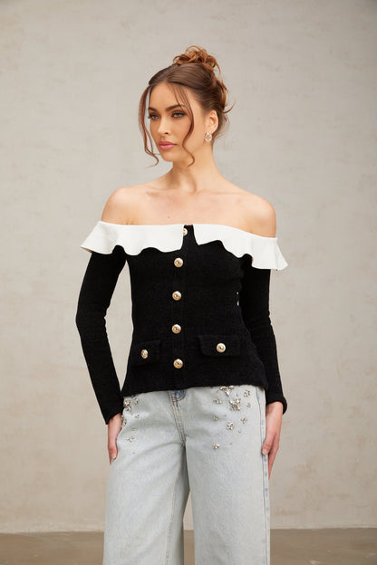 Woman wearing black off shoulder top with ruffled details
