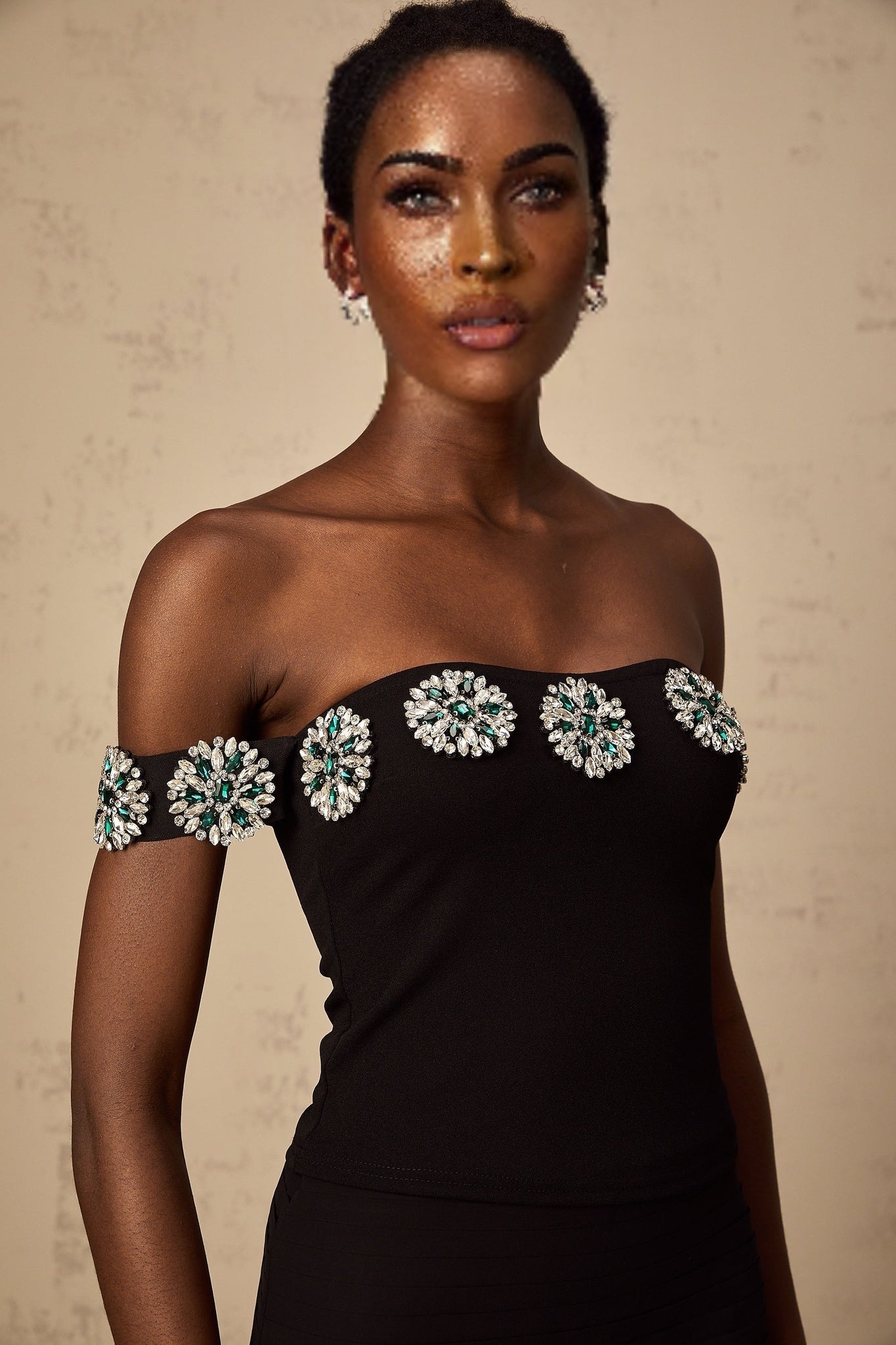 Woman wearing black offshoulder top with embellishments