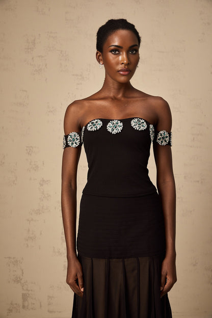 Woman wearing black offshoulder top with embellishments