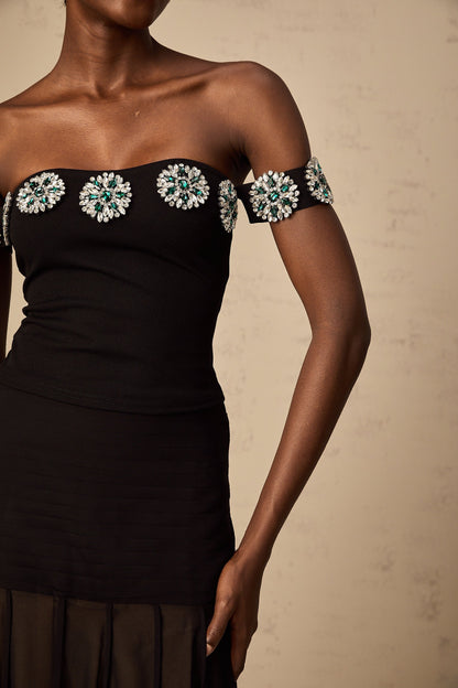 Woman wearing black offshoulder top with embellishments