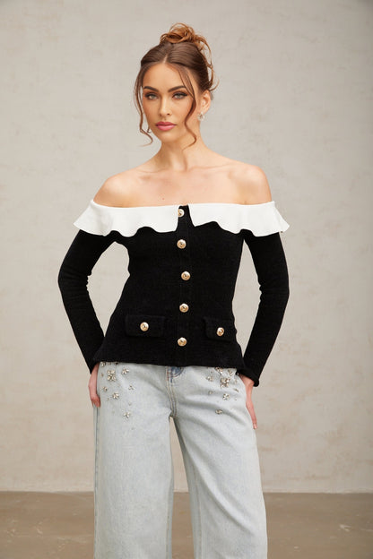Woman wearing black offshoulder top with ruffled neckline