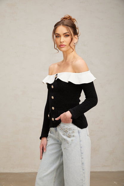 Woman wearing black offshoulder top with ruffled neckline