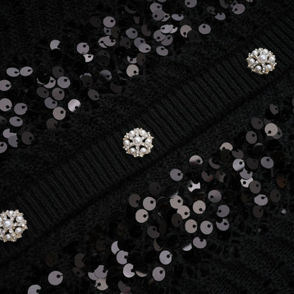 Woman wearing black sequined cardigan and matching skirt set with crochet knit texture