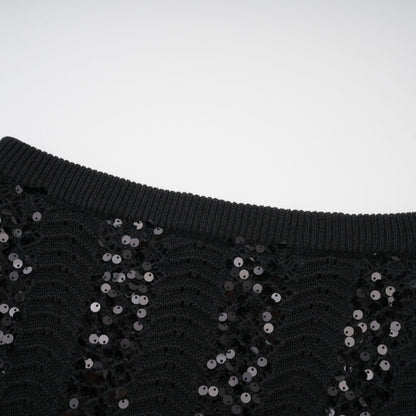 Woman wearing black sequined crochet knit cardigan and matching skirt set