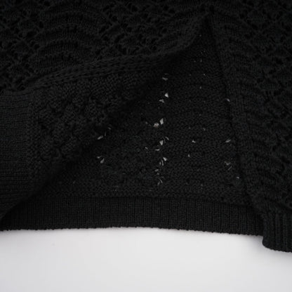 Woman wearing black sequined crochet knit cardigan and matching skirt set