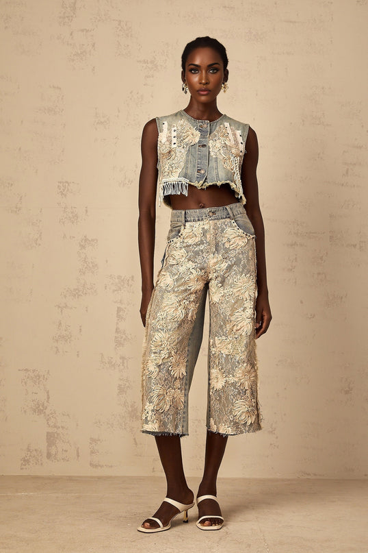 Woman wearing blue cropped denim top with lace panels and short sleeves