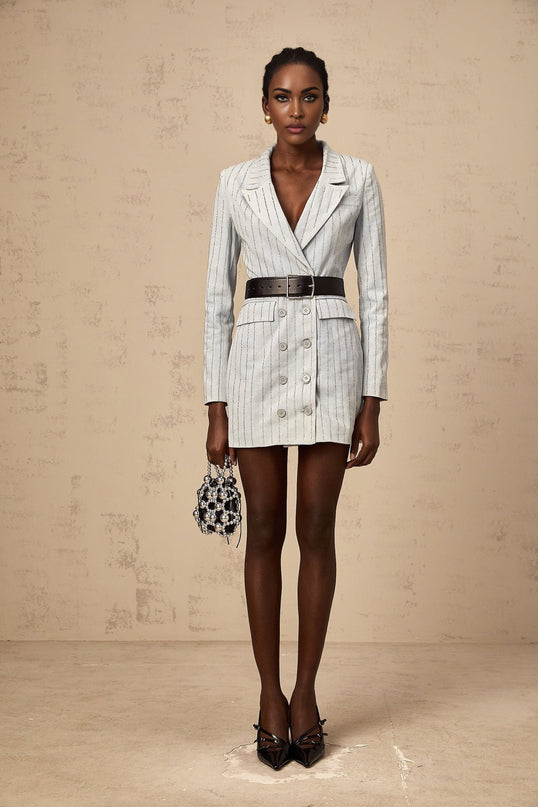 Woman wearing blue denim mini dress with rhinestone embellishments and blazer style collar and lapels