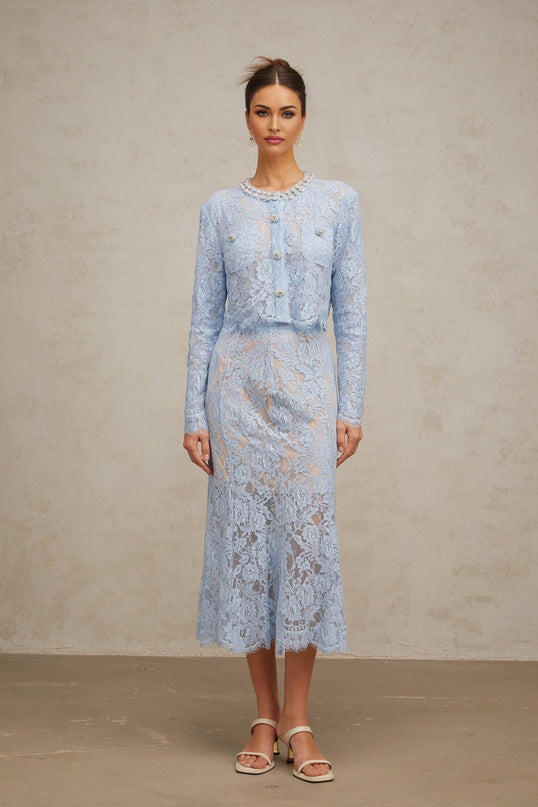 Woman wearing blue floral lace matching top and skirt set with delicate pattern and feminine design