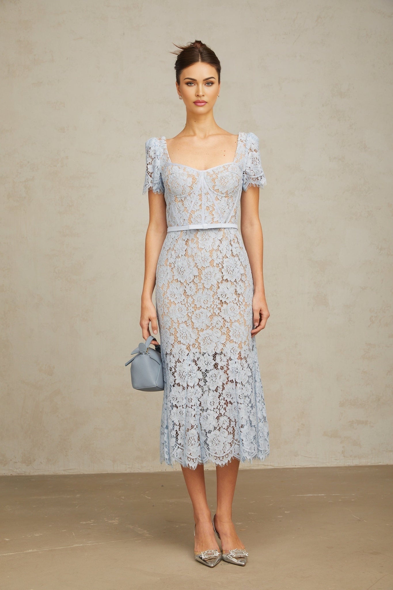 Woman wearing blue floral lace midi dress with boned bodice and fitted silhouette